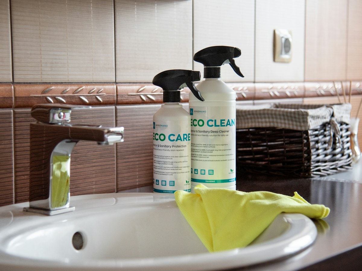 a bathroom sink with two cleaning products on it