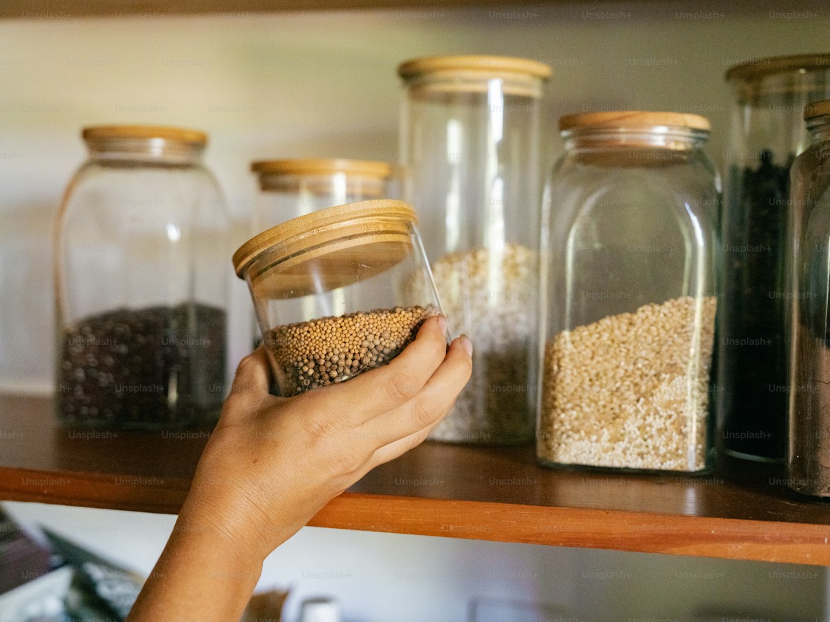 A person reaching for a jar on a shelf
